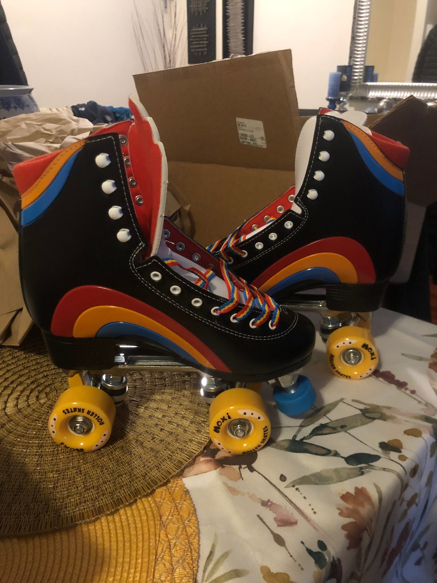 A pair of rainbow and black skates on a table.