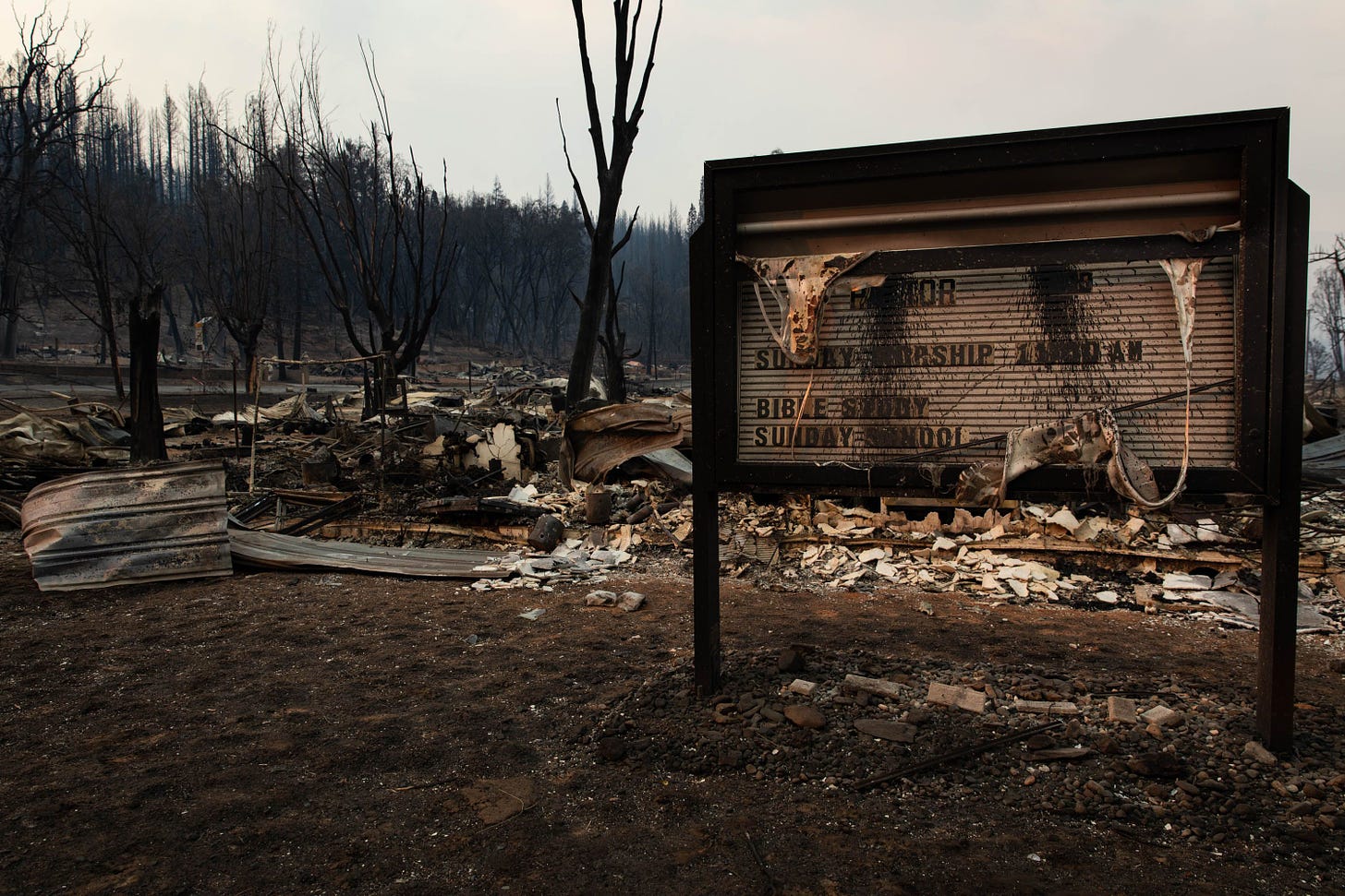 2021 年 8 月 8 日，在迪克西大火席卷该镇后，加利福尼亚州格林维尔教堂建筑被烧毁的遗迹附近的教堂标志残余物（来源：Marani R. Staab / Getty Images）