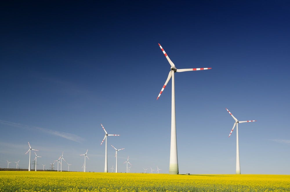 windmills on grass field at daytime