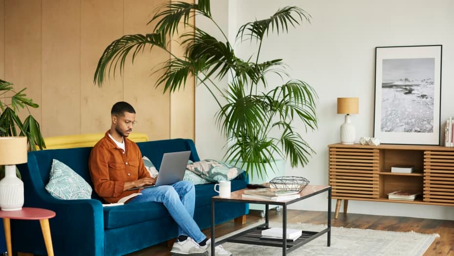 A remote employee working from home on his couch