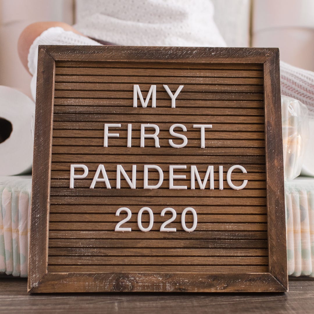 women posing with letter board and toilet paper. Letter board says My First Pandemic 2020
