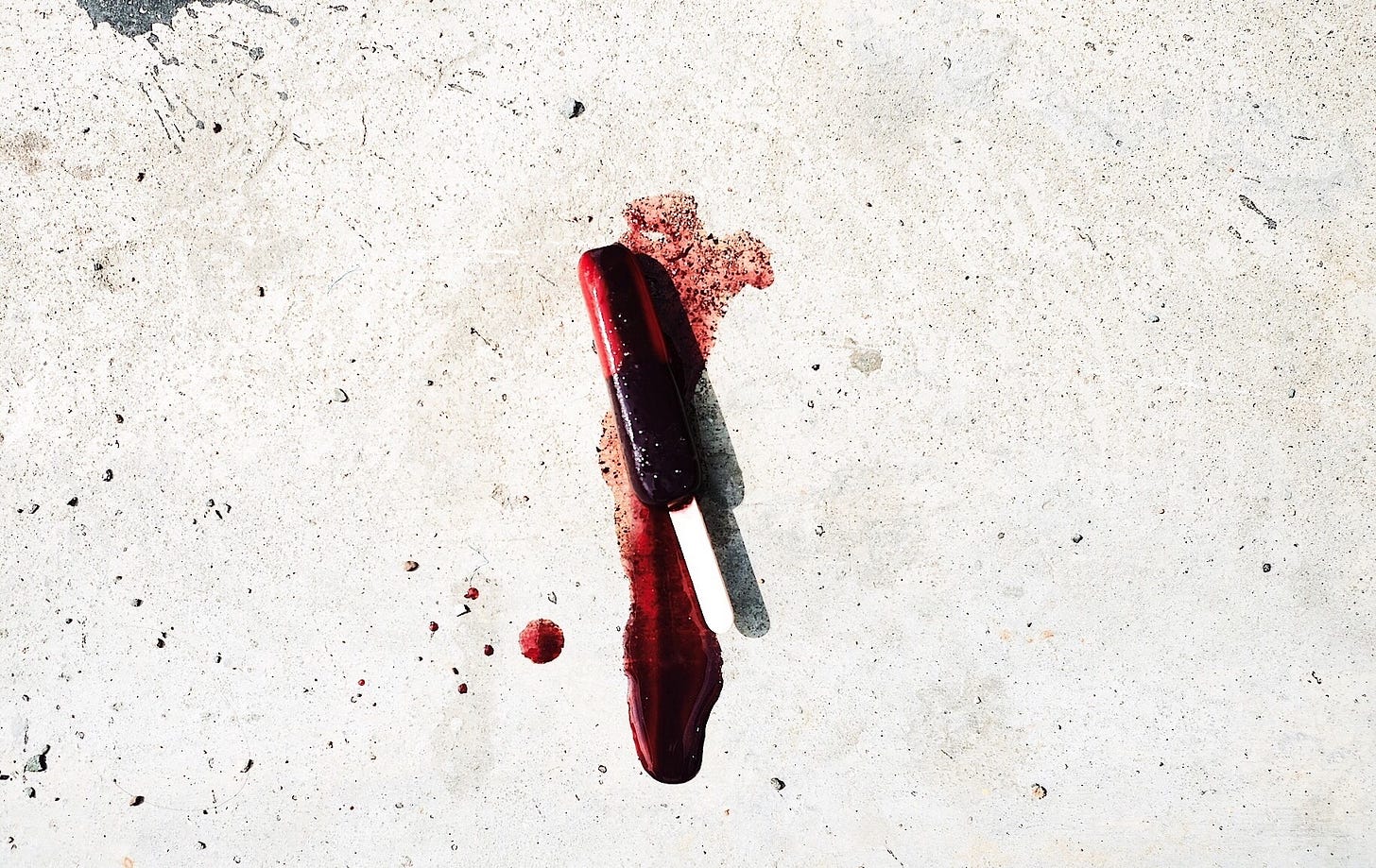 A melting black and bloodred popsicle .It more resembles a crime scene than a dessert