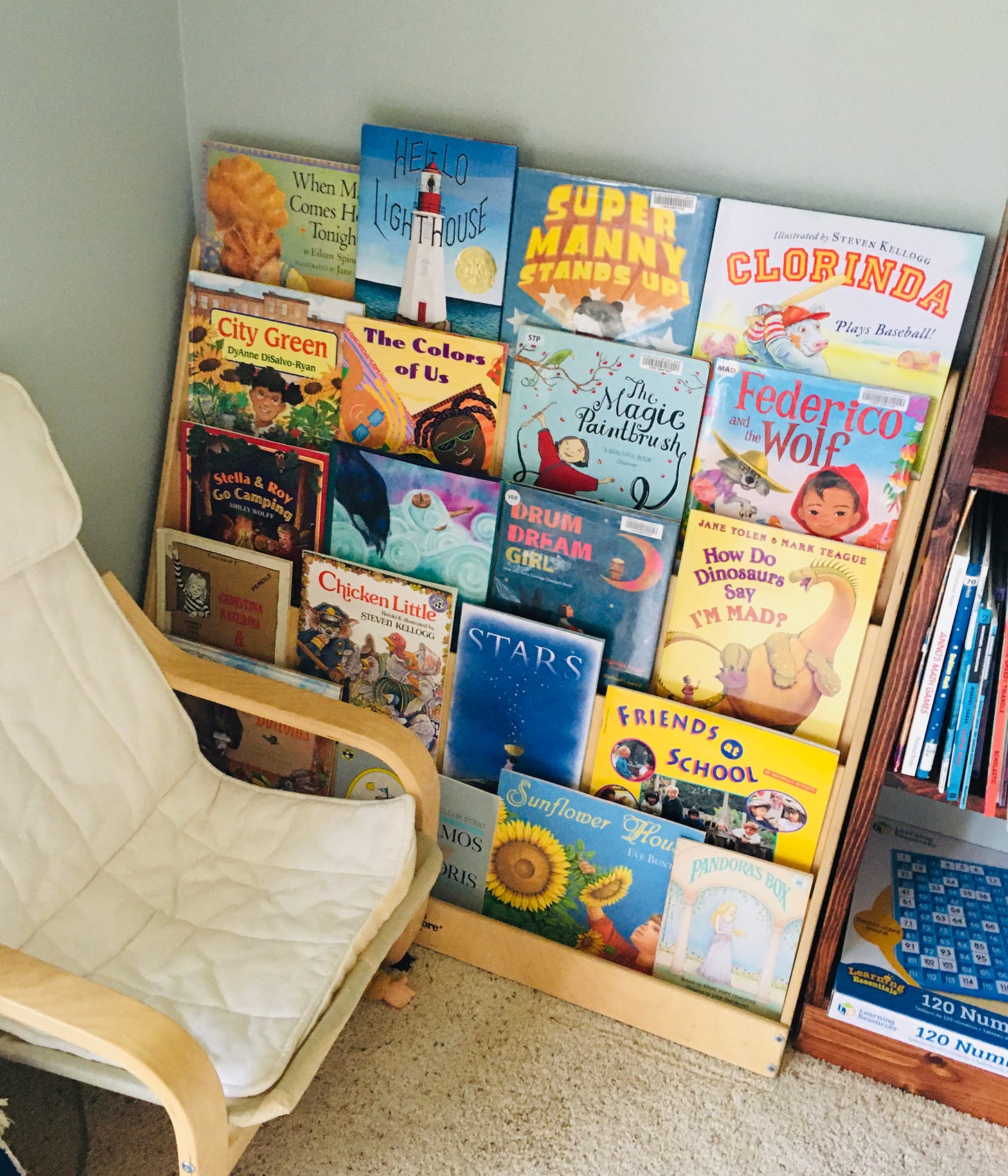 A low bookshelf with five rows of children's books, all facing out so their covers show