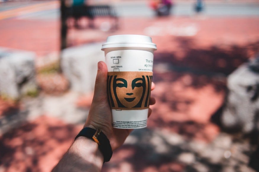 a person holding a Starbucks coffee cup