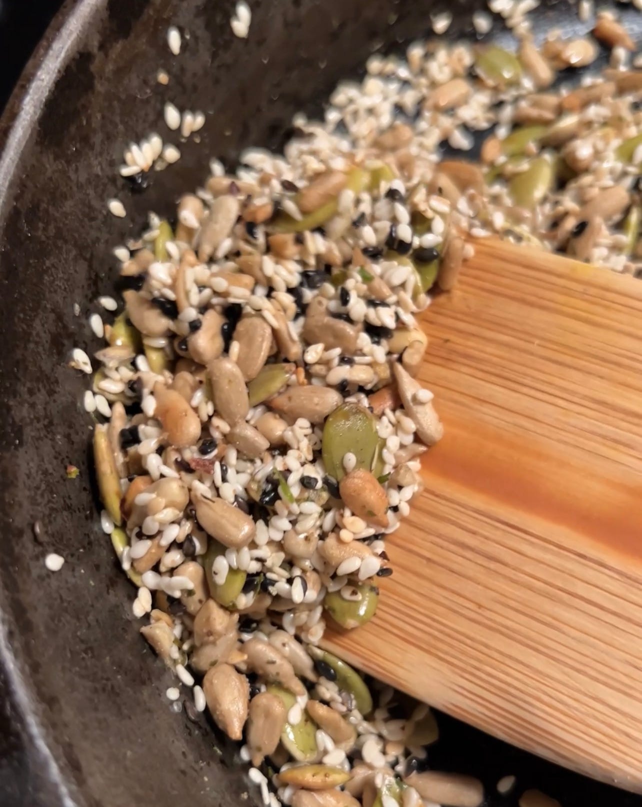 Sesame seeds, pepitas, sunflower seeds in a cast iron pan.