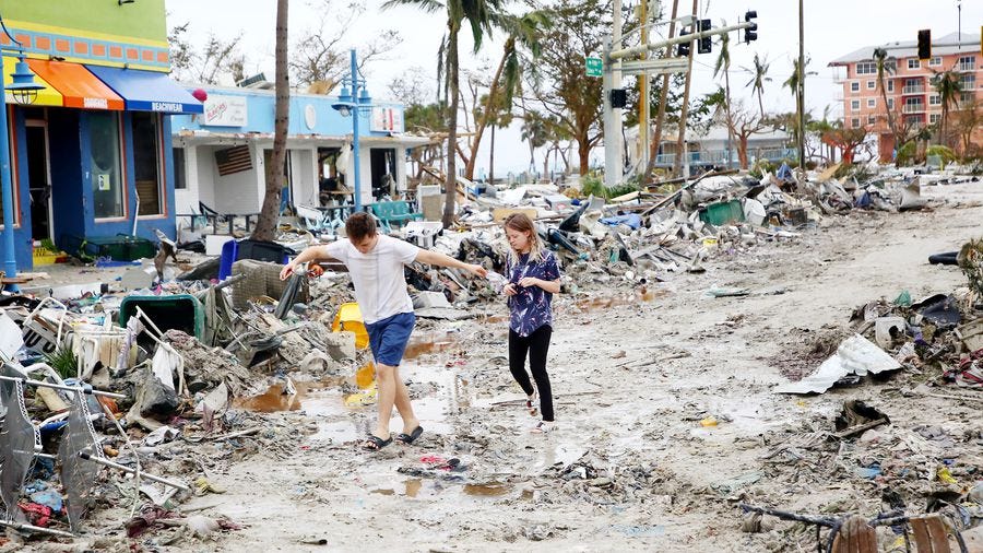 Jake Moses, 19, left, and Heather Jones, 18, of Fort Myers, explore a section of destroyed businesses at Fort Myers Beach on Thursday, Sep 29, 2022. The community was mostly destroyed after Hurricane Ian made landfall on Wednesday.