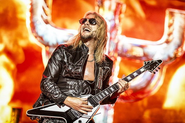 Richie Faulkner of Judas Priest on stage holding a guitar