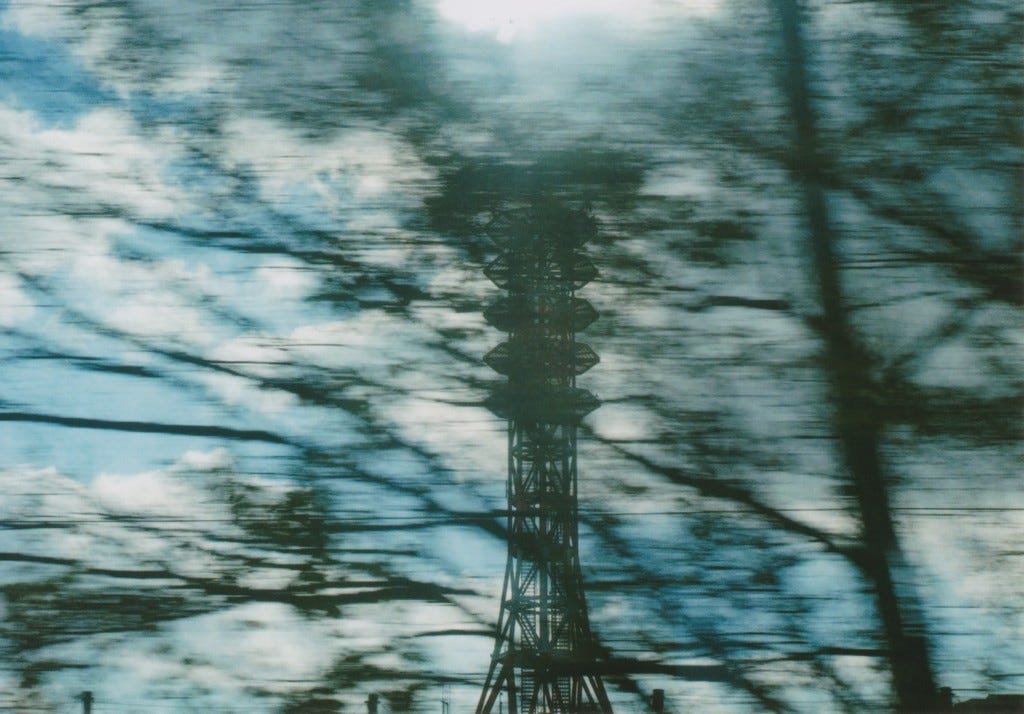 A photo of a radio tower taken from a moving car or train.