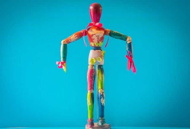 Against a cyan background, a multicoloured drawing mannequin stood with their upper arms held out, lower arms hanging down