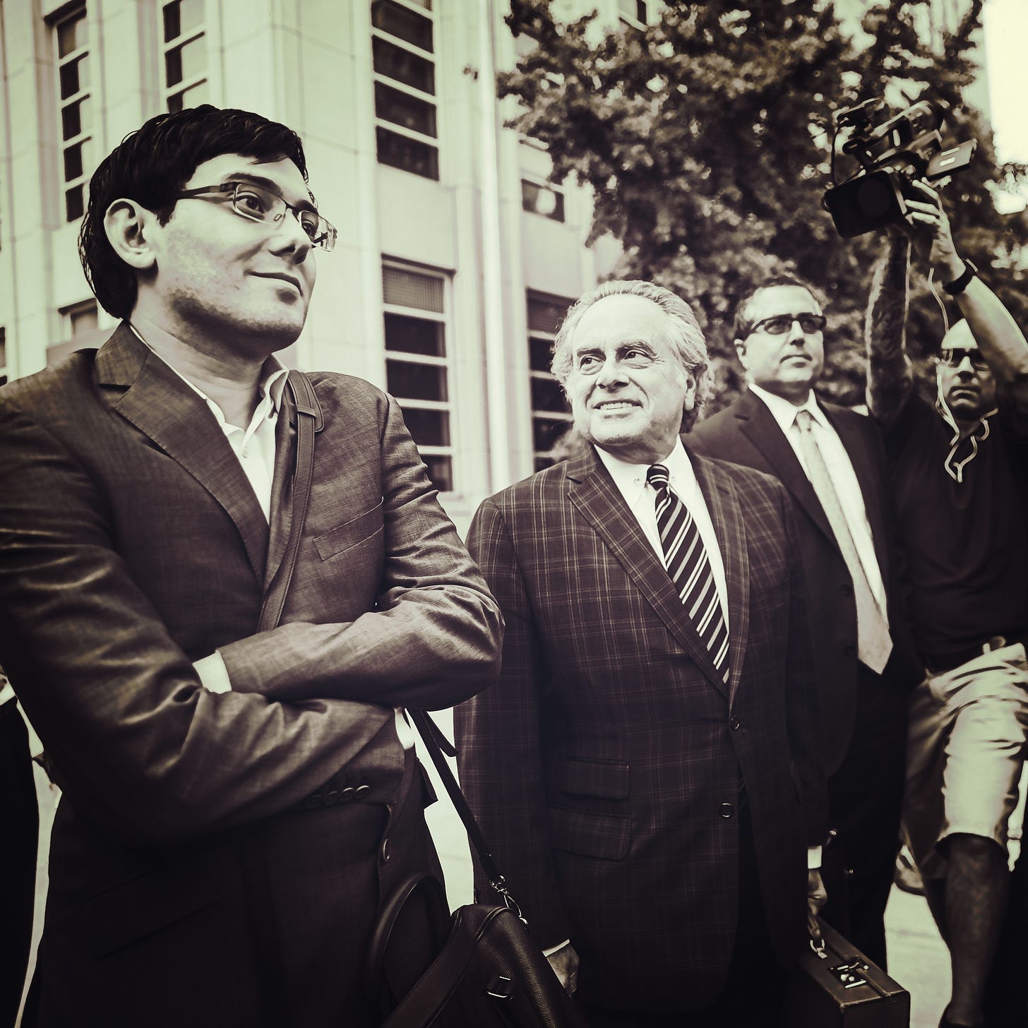 Martin Shkreli next to lawyer Benjamin Brafman outside the federal courthouse in Brooklyn. (Another one of Martin’s lawyers, Marc Agnifilo, is standing to the right of Brafman.) (Getty Images.) 