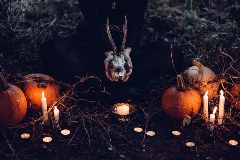 Candles, pumpkins, horned skull.