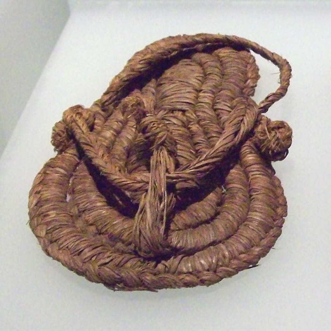 A Neolithic Sandal from Albuñol, Spain dated between 5200 - 4800 BCE. The sandal is incredibly intact and is very similar to our modern designs with a toe thong and straps to keep it firmly on the foot. It seems to be made from some sort of thickly corded and wrapped plant fiber.
