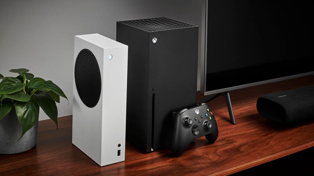 Xbox Series S and Xbox Series X standing vertically on a wooden table