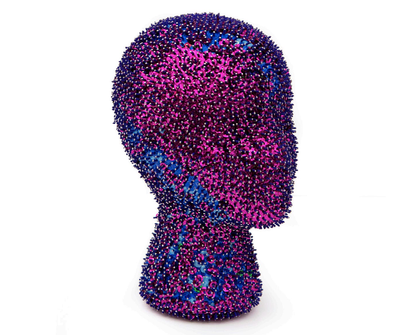 A mixed media sculpture of a nondescript head has lots of shiny purples and pinks and blues with what looks like pins that cover the entire surface.