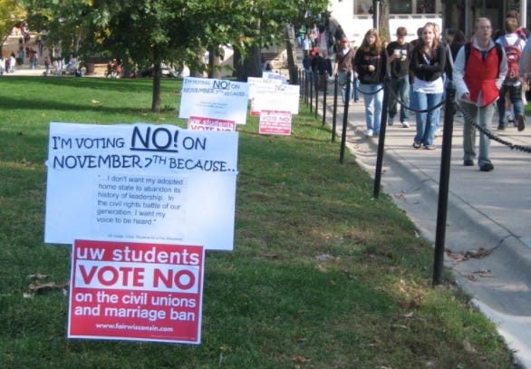 Signs urging a "no" vote on the 2006 Wisconsin same-sex marriage ban on Bascom Hill, while students walk by.