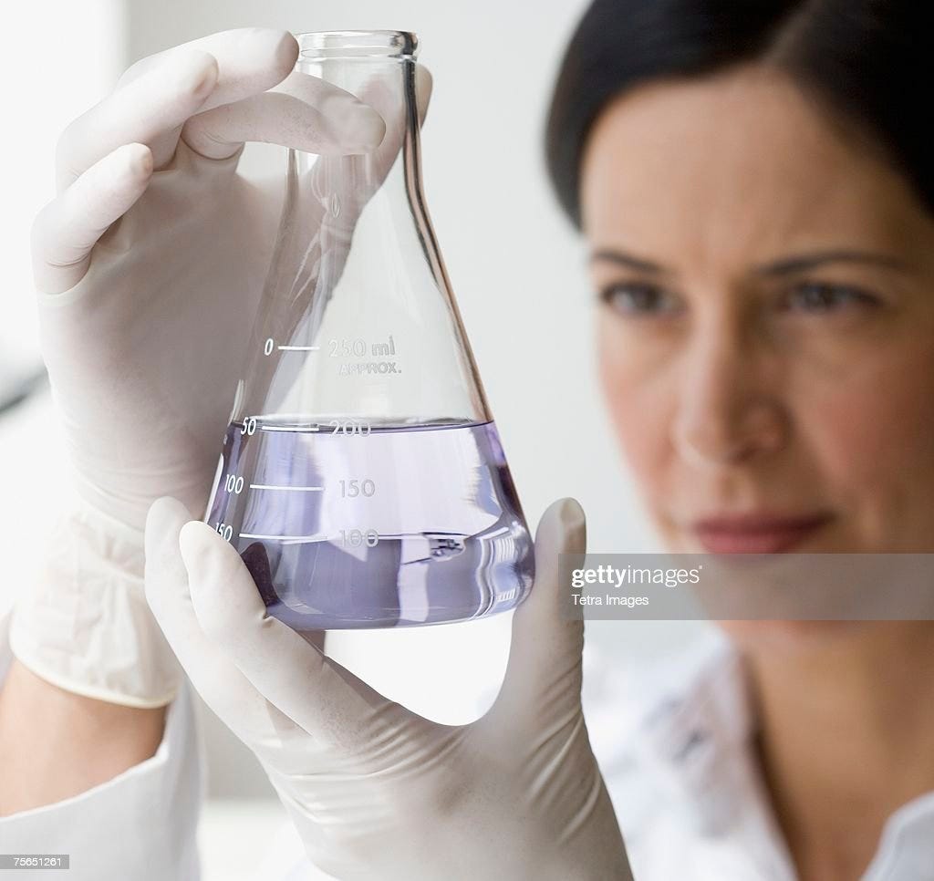 Female Scientist Looking At Liquid In Beaker High-Res Stock Photo ...
