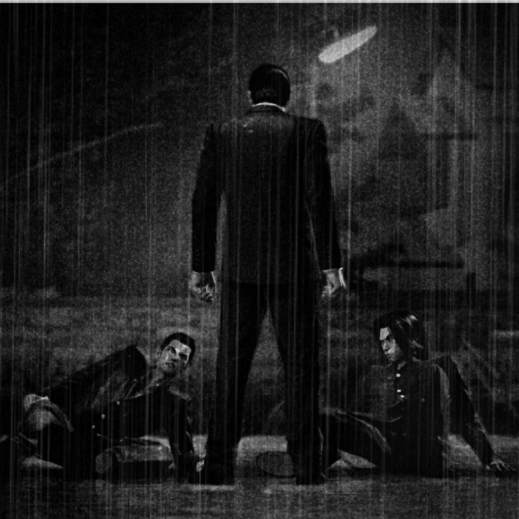 A black and white image of Kiryu and his sworn brother as teenagers. It is raining. The image is dark, gloomy. The boys' father is looming over them, his back to the camera.