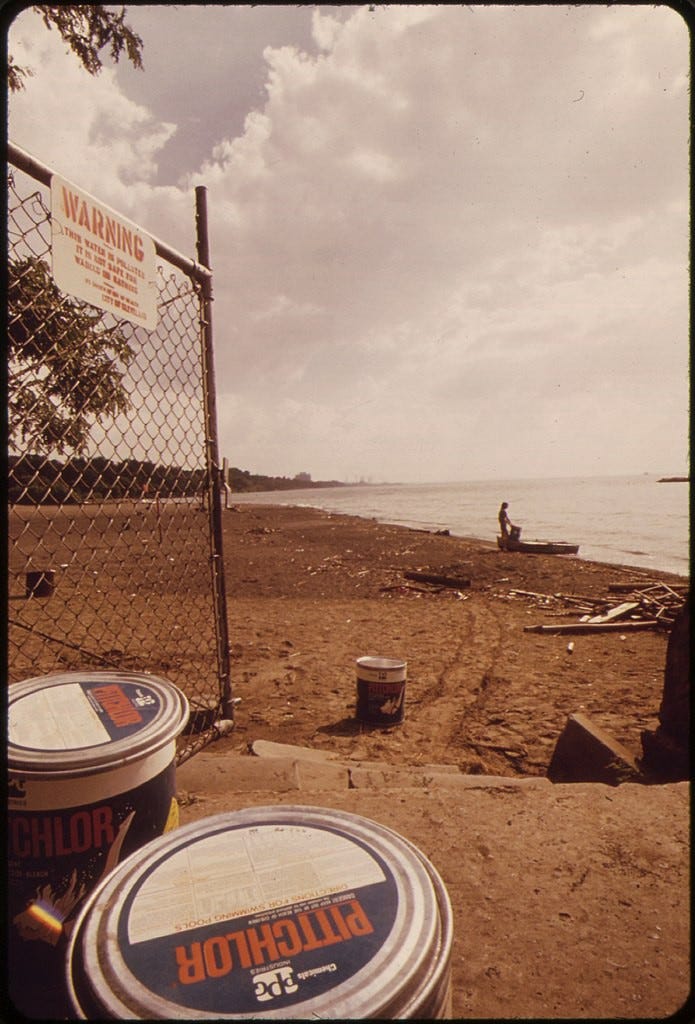 1973 IMAGE. WHITE CITY BEACH SIGN WARNS AGAINST SWIMMING IN POLLUTED LAKE ERIE. TO REDUCE POLLUTION, LIFEGUARDS ARE SEEN POURING CHLORINE INTO THE WATER ONCE EVERY HOUR.