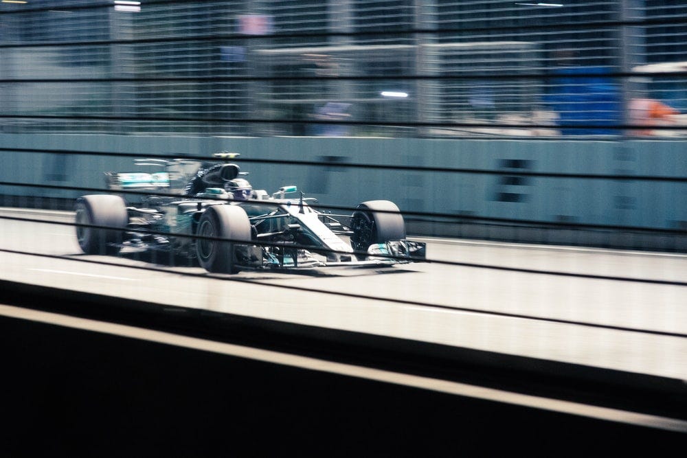 green Formula 1 car on grey track at daytime green Formula 1 car on grey track at daytime