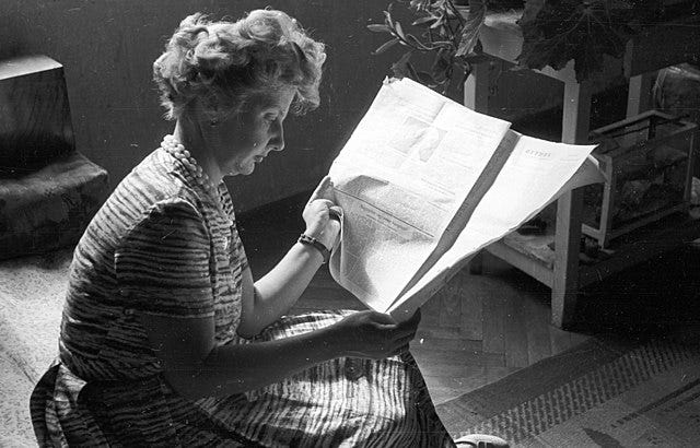 Photograph of woman reading newspaper, from Hungary around 1962, courtesy of Wikimedia Commons