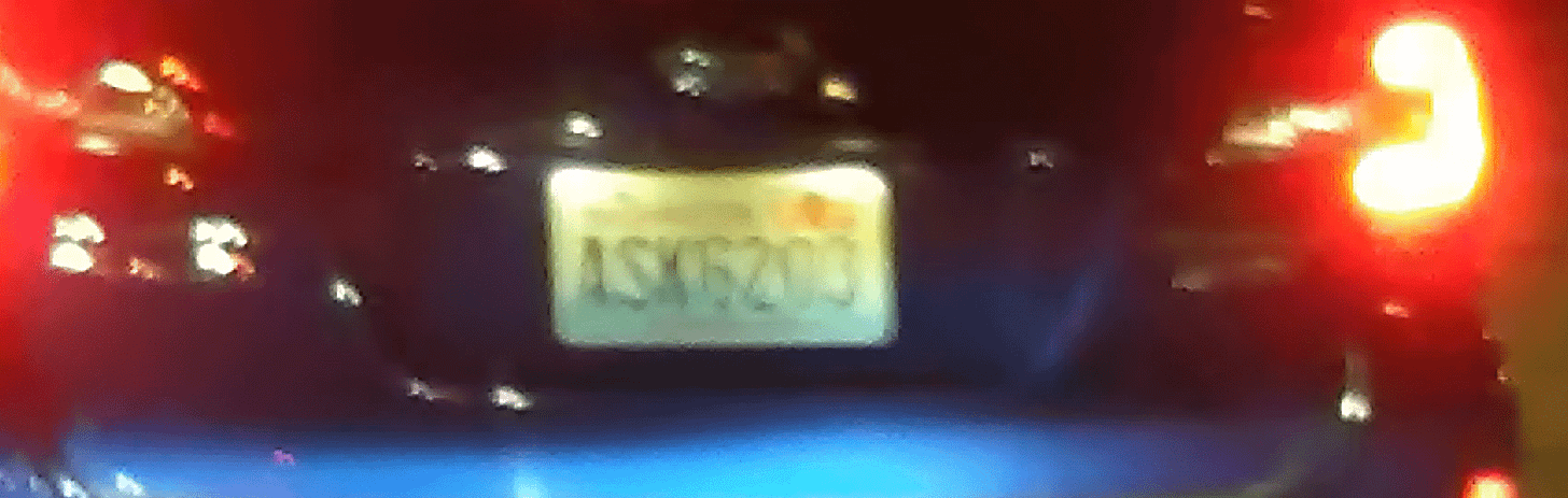 Another license plate with ASK and my favorite numbers: 2, 3, and 6. Car has bright red brake lights on.