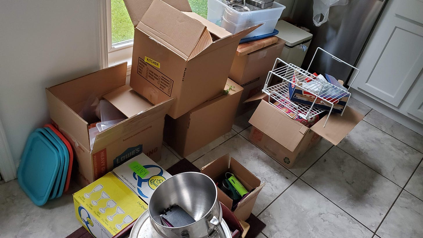 Photo of a kitchen floor with stacks of boxes, contents spilling out