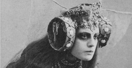 Fotografia antiga da Baronesa Elsa Von Freytag usando uma fantasia excêntrica, com o que parecem ser dois tambores pequenos amarrados ao redor de sua cabeça
