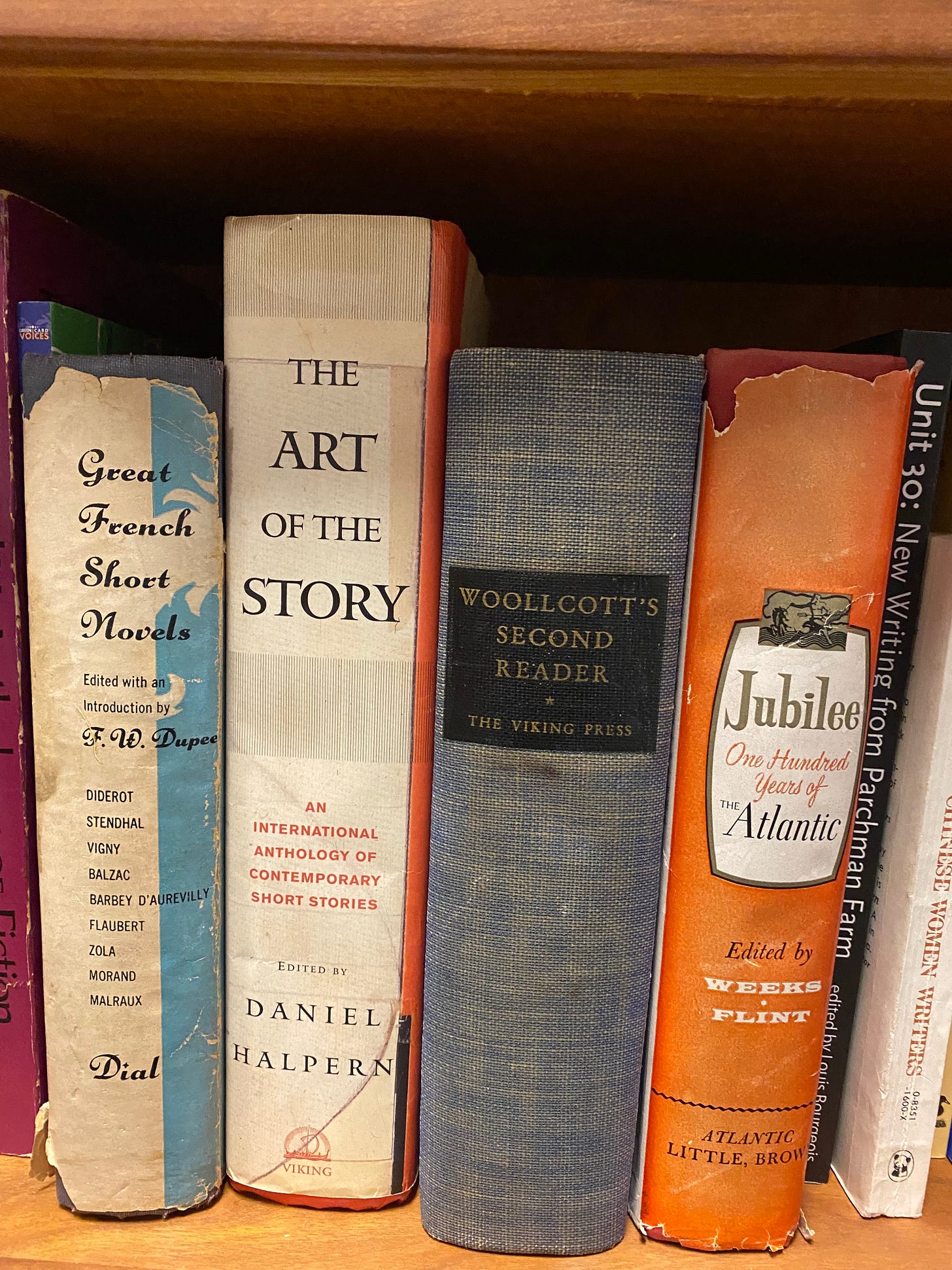 Spines of 5 and a half literature anthologies, including Woollcott's Second Reader, Great French Short Novels, The Art of the Story, and Jubilee: One hundred Years of the Atlantic