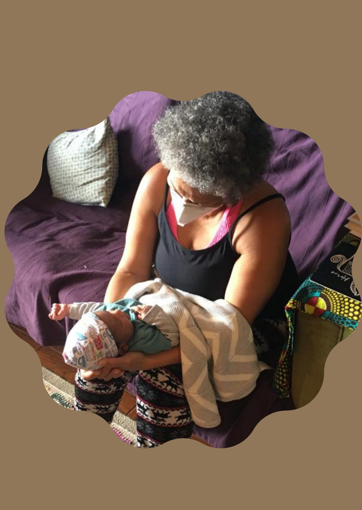 Mama P, wearing a mask, holding her new grandchild.