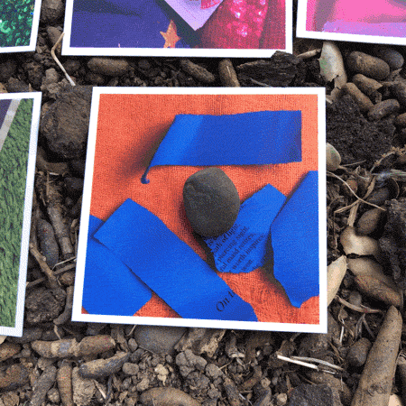 An animated photo loop of an orange and blue card laid out in a grid of other Rainbow Squared cards under an oak tree amidst California hills. 