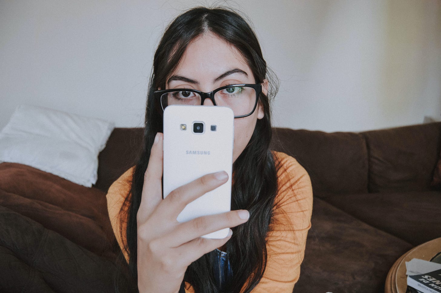 young woman with glasses looking at her mobile phone