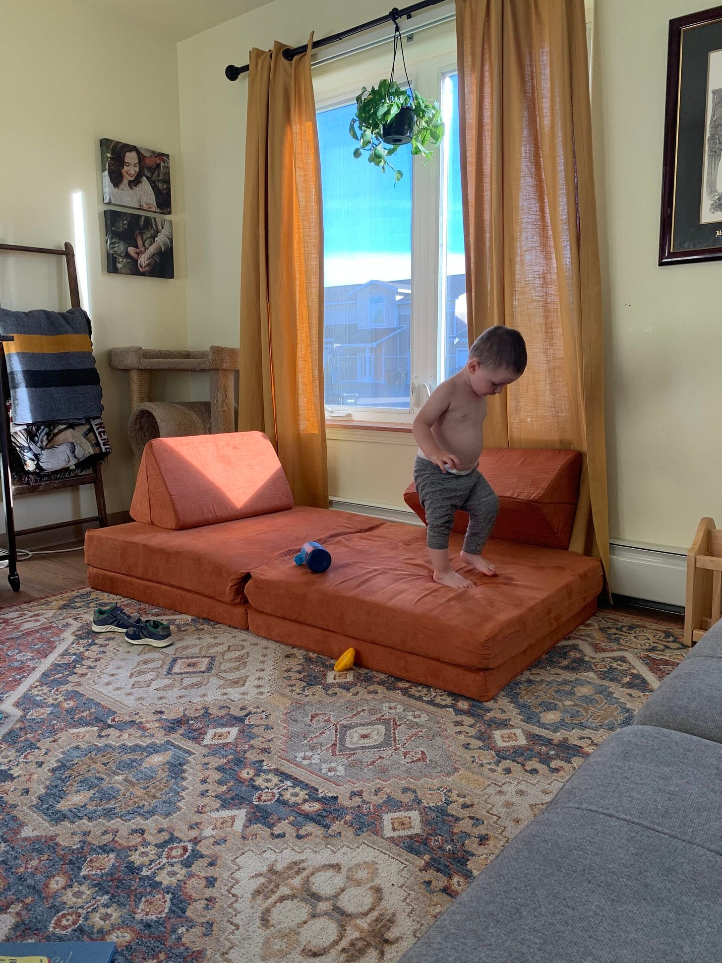 A toddler runs across a Nugget comfort couch in the color Rodeo