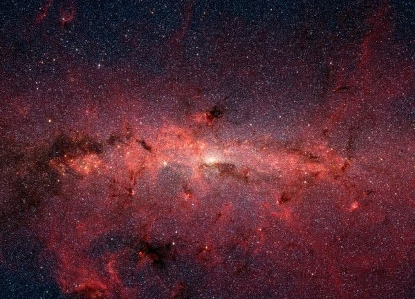 The starry core of our spiral Milky Way galaxy, in an infrared image from NASA Spitzer Space Telescope. Obscured behind it is the South Pole Wall, a curtain of thousands of galaxies across at least 700 million light-years.