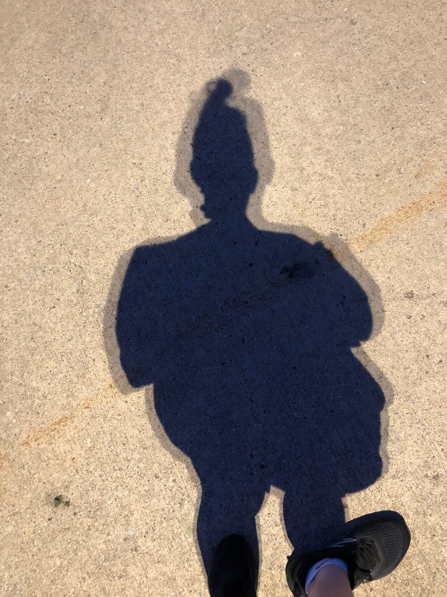 the shadow of a person cast on concrete with the appearance of doubling