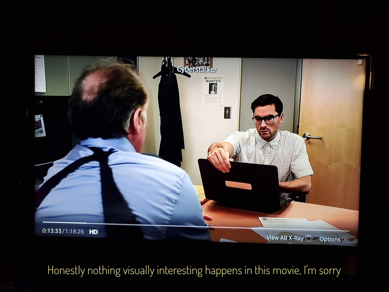 Dan Levy grabbing a laptop in a small office, captioned "Honestly nothing visually interesting happens in this movie, I'm sorry"