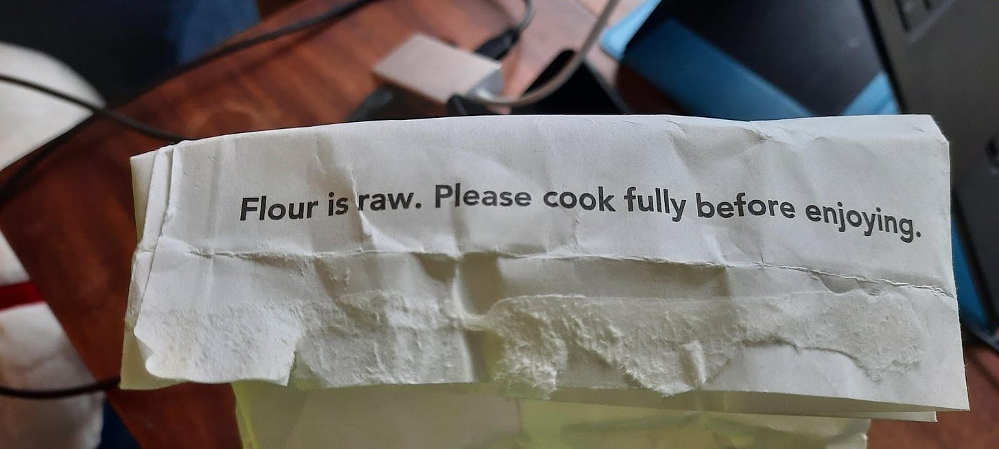 Photo of the top of a flour bag. It says: "Flour is raw. Please cook fully before enjoying."