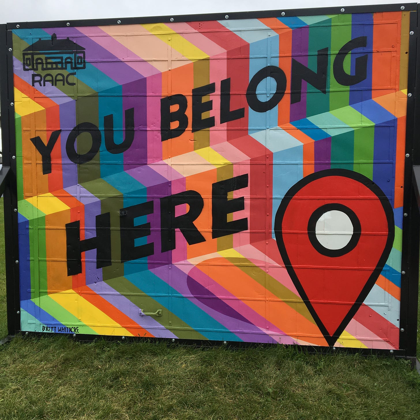 a colorful mural that says "you belong here"