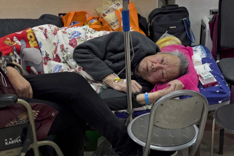 An elderly man takes a rest along a corridor in an emergency ward as he receives an intravenous drip in Beijing, Tuesday, Jan. 3, 2023. As the virus continues to rip through China, global organizations and governments have called on the country start sharing data while others have criticized its current numbers as meaningless. (AP Photo/Andy Wong)