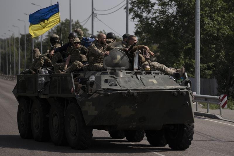 FILE - Ukrainian servicemen ride atop of an armored vehicle on a road in Donetsk region, eastern Ukraine, Sunday, Aug. 28, 2022. As the war slogs on, a growing flow of Western weapons over the summer is now playing a key role in the counteroffensive, helping Ukraine significantly boost its precision strike capability. (AP Photo/Leo Correa, File)