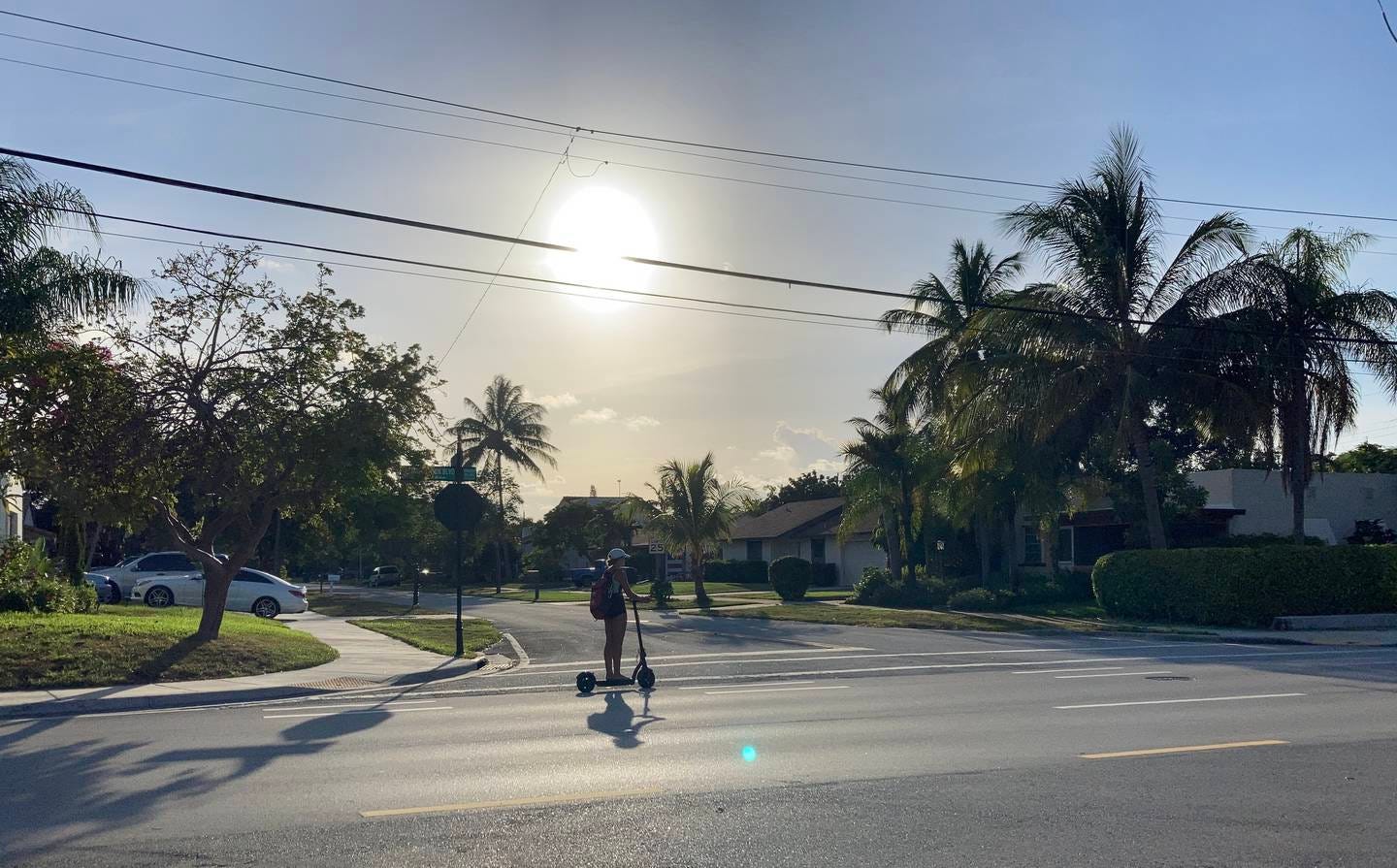 A woman rides an electric scooter on Northwest Second Avenue heading north in the general direction of Florida Atlantic University on Thursday evening. She was seen leaving downtown Boca Raton along Palmetto Park Road. (Kathy Laskowski/South Florida Sun Sentinel)