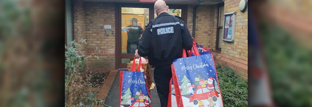 photograph of officer delivering Christmas gifts