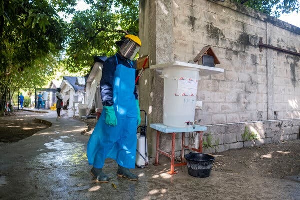 A hospital worker at a disinfecting station at the cholera treatment unit of the Médecins Sans Frontières hospital in Cite Soleil, a densely populated neighborhood of Port-au-Prince.