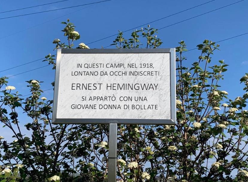 Un cartello recita "In questi campi, nel 1918, lontano da occhi indiscreti Ernest Hemingway si appartò con una giovane donna di Bollate