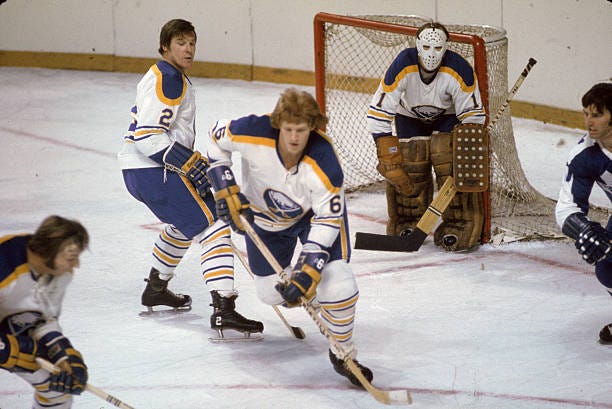 Canadian professional hockey player Tim Horton of the Buffalo Sabres skates in front of goalie Roger Crozier as teammate Jim Schoenfeld defends...