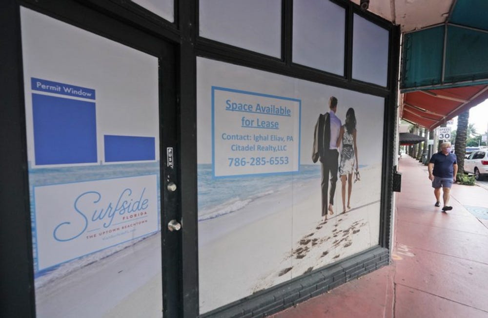 A pedestrian walks by an empty business with space for lease in October in Surfside, Florida