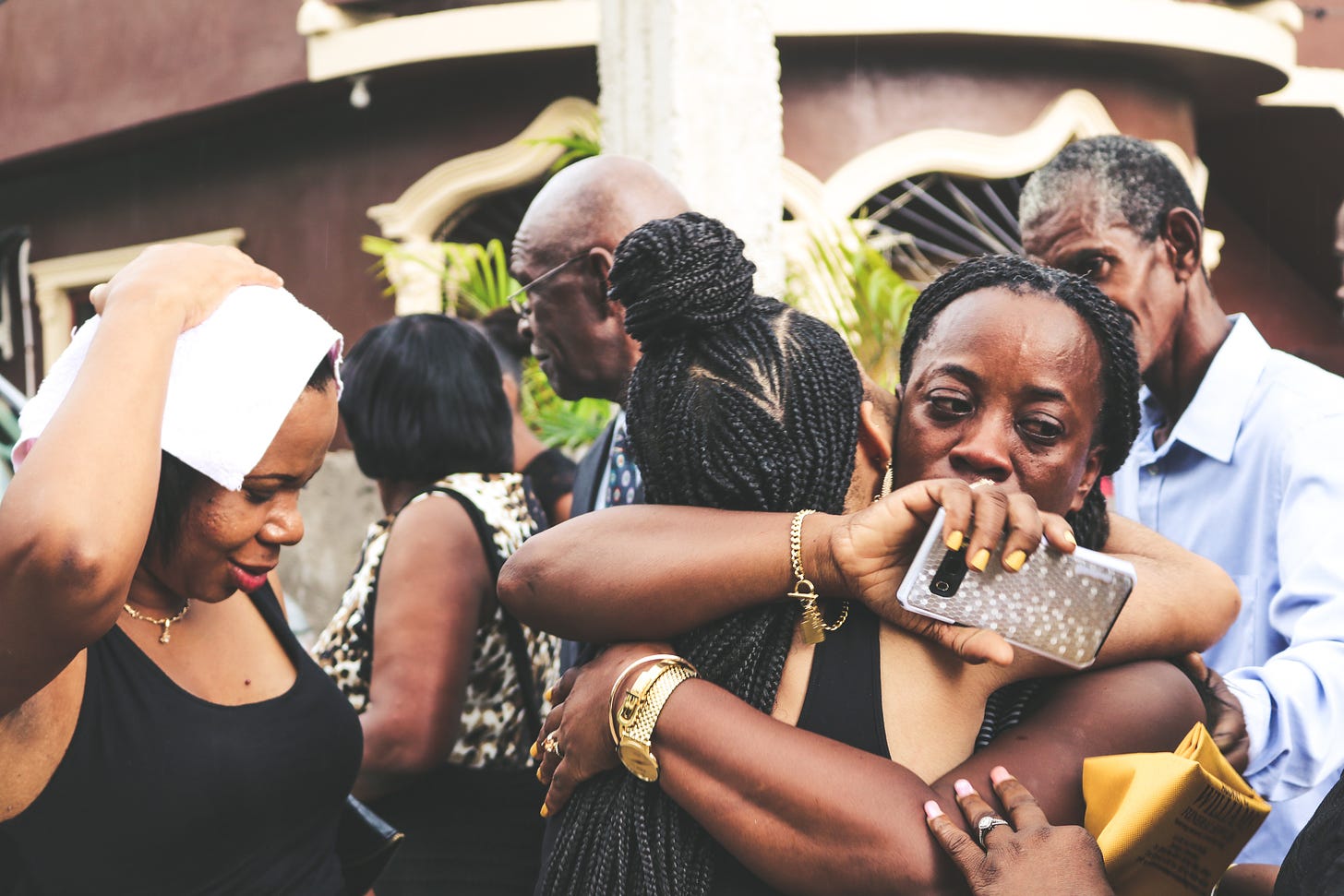 Black women embracing at a funeral.