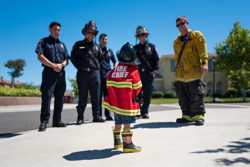 A little boy wearing a firefighter uniform