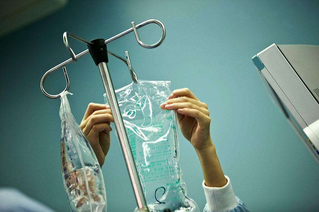 An IV bag is hung from a pole.