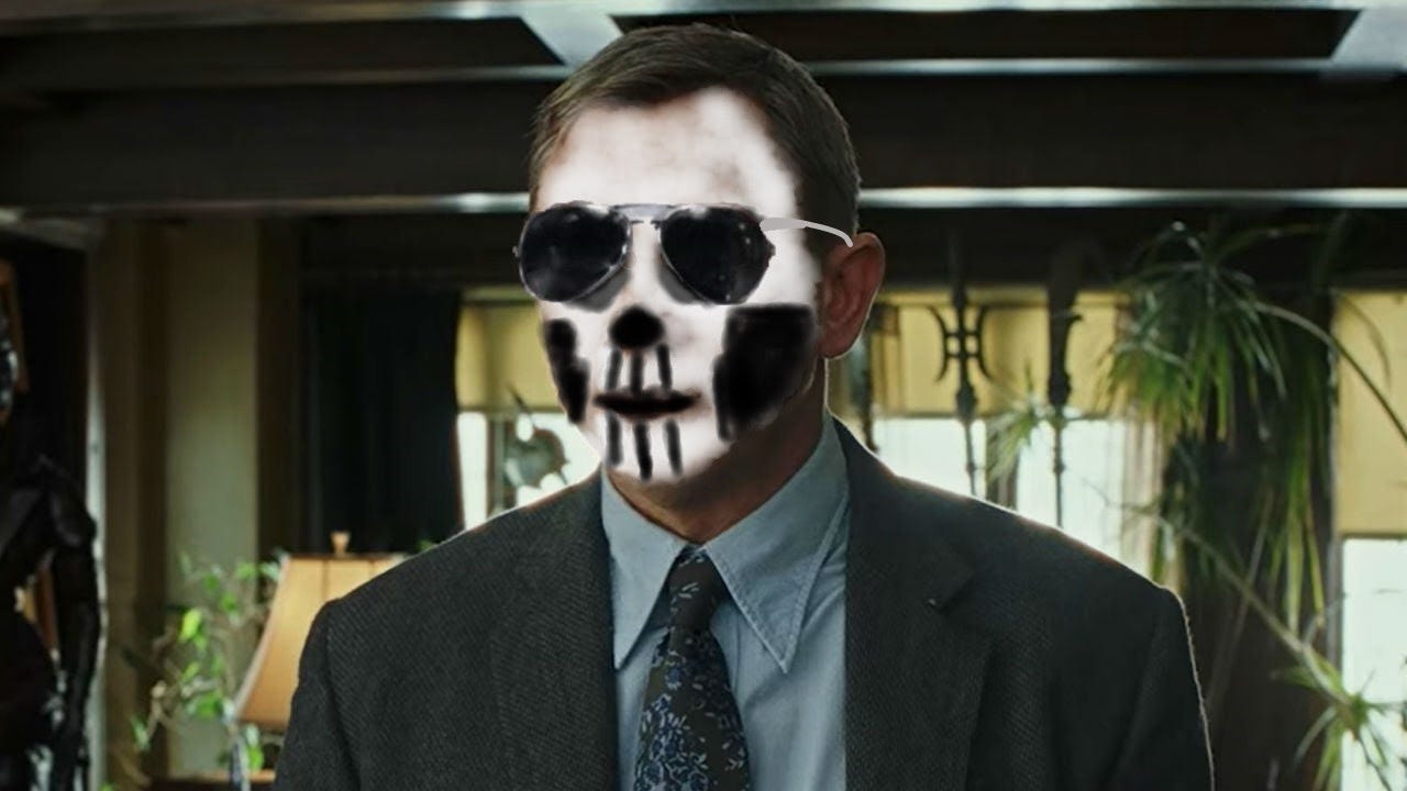 daniel craig as benoit blanc, a man with short-cropped hair and a suit, but with face paint of a skull crudely drawn over his face in Microsoft Paint, as well as aviator sunglasses. He looks like Gideon the Ninth on the cover of her eponymous book