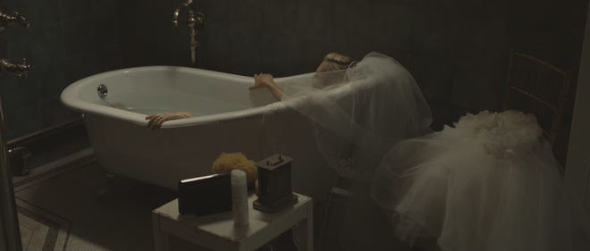 Film still from Melancholia. Justine sits in a bath, wedding veil still on.